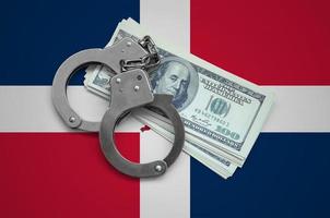 Dominican Republic flag  with handcuffs and a bundle of dollars. Currency corruption in the country. Financial crimes photo