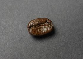 grano de café tostado sobre fondo negro foto