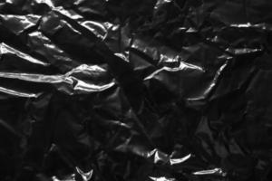 transparent plastic bag film wrap overlay texture on black background photo