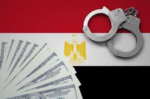 Egypt flag  with handcuffs and a bundle of dollars. The concept of illegal banking operations in US currency photo