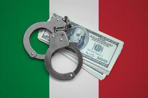 Italy flag  with handcuffs and a bundle of dollars. Currency corruption in the country. Financial crimes photo