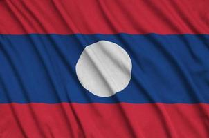 Laos flag  is depicted on a sports cloth fabric with many folds. Sport team banner photo