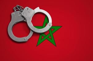 Morocco flag  and police handcuffs. The concept of crime and offenses in the country photo