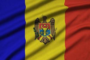 Moldova flag  is depicted on a sports cloth fabric with many folds. Sport team banner photo