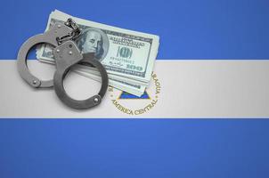 Nicaragua flag  with handcuffs and a bundle of dollars. The concept of breaking the law and thieves crimes photo