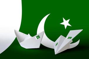 Pakistan flag depicted on paper origami airplane and boat. Handmade arts concept photo