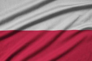 la bandera de polonia está representada en una tela deportiva con muchos pliegues. bandera del equipo deportivo foto