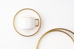 A set of white and brown ceramic plate and cup on a white background. Top view photo