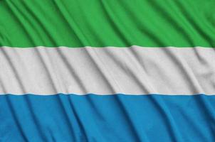 Sierra Leone flag  is depicted on a sports cloth fabric with many folds. Sport team banner photo