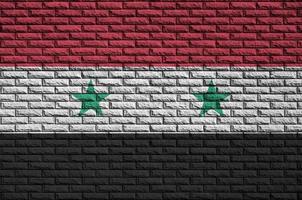 la bandera de siria está pintada en una pared de ladrillo vieja foto