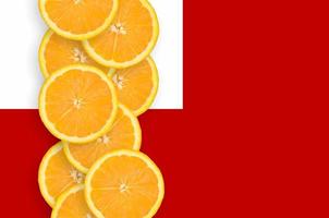 Tonga flag and citrus fruit slices vertical row photo