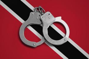 Trinidad and Tobago flag  and police handcuffs. The concept of observance of the law in the country and protection from crime photo