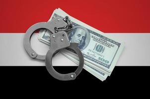 Yemen flag  with handcuffs and a bundle of dollars. Currency corruption in the country. Financial crimes photo