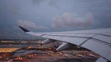 vista do assento da janela de um avião decolando com asa e aeroporto à vista video