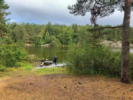 A woman standing near a lake photo