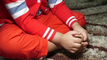 Child sits in a rug fidgeting with toes and hands video