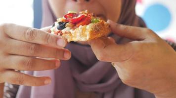 Frau isst ein Stück Pizza mit Peperoni und Oliven video