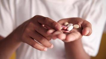 Person looks through and picks up different pills from palm of hand