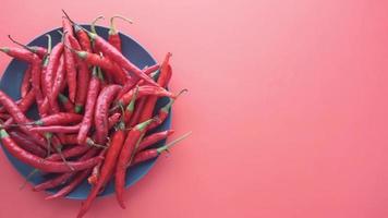 Red cayenne peppers on a plate with red background video