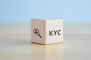 KYC on wooden cubes. know your customer with magnifying glass. Business verifying the identity of its clients concept photo