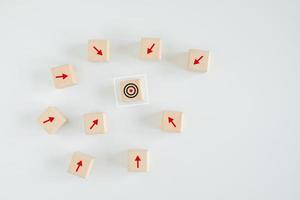 Business achievement goal and objective target. Growing business success concept. Wooden block with dart board on center and many arrow pointing to the target.