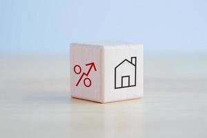 House and property investment and asset management concept. Loan, Mortgage, Inflation, Sale and tax rise. House icon and percentage sign on wooden block. Home price or increase of interest rate. photo