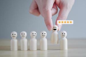 Business hiring and recruitment selection. Mental Health, Emotion, Satisfaction. Hand holding happy figure with 5 star from group of crowd. Choosing leader or employee to team with positive attitude. photo