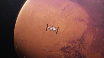 Vista telescópica del planeta Marte tomada desde el espacio. exploración de satélites en órbita marciana. planeta rojo en el espacio ultraterrestre iluminado por el sol en 4k video
