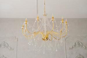 Gold crystal chandelier in a classic style in the interior of the house photo