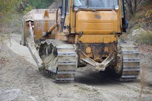 agregado de cantera con maquinaria pesada. Excavadora de oruga con retroexcavadora que conduce a la cantera del sitio de construcción foto