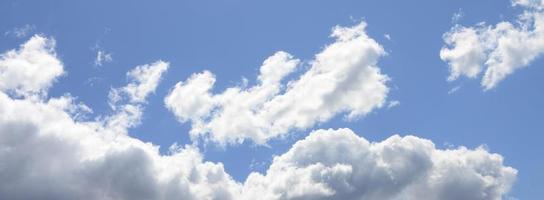 A blue sky with lots of white clouds of different sizes photo