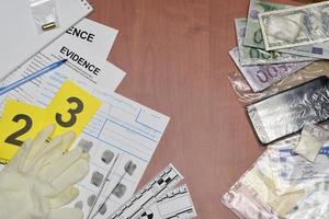 Paperwork during crime scene investigation process in csi laboratory. Evidence labels with fingerprint applicant and many confiscated personal items on wooden table photo