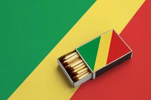 Congo flag  is shown in an open matchbox, which is filled with matches and lies on a large flag photo