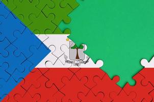Equatorial Guinea flag  is depicted on a completed jigsaw puzzle with free green copy space on the right side photo