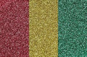 Guinea flag depicted on many small shiny sequins. Colorful festival background for party photo