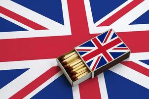 Great britain flag  is shown in an open matchbox, which is filled with matches and lies on a large flag photo