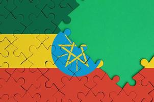 Ethiopia flag  is depicted on a completed jigsaw puzzle with free green copy space on the right side photo