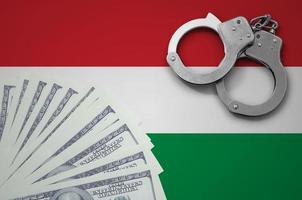 Hungary flag  with handcuffs and a bundle of dollars. The concept of illegal banking operations in US currency photo