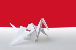 Indonesia flag depicted on paper origami crane wing. Handmade arts concept photo