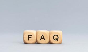 FAQ or Frequently Asked Questions concept. Text on Wooden block shape on gray background. Copy space photo