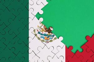 Mexico flag  is depicted on a completed jigsaw puzzle with free green copy space on the right side photo