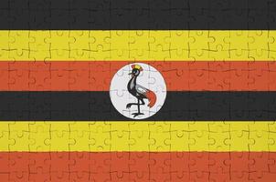 Uganda flag  is depicted on a folded puzzle photo