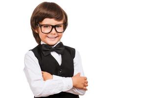 I know a lot of things. Portrait of young boy in bow tie looking at camera and smiling while isolated on white photo