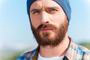 Confident handsome. Portrait of handsome bearded man looking at camera while standing outdoors photo