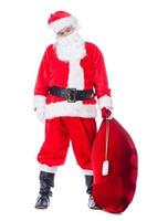 Tired Santa Claus. Full length of tired Santa Claus carrying sack with presents while standing against white background photo