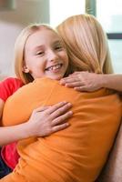 I love you mom Happy mother and daughter hugging while sitting on the couch together photo