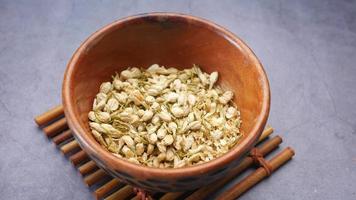 Loose leaf dried jasmine flowers in a wooden bowl video