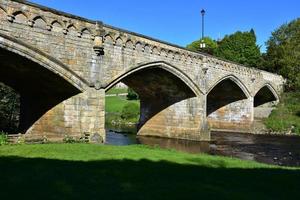 Attractive Arched Stone Bridge Over a Flowing River photo