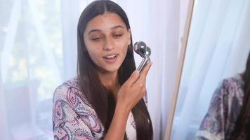 Young beautiful woman uses facial roller in skincare routine video