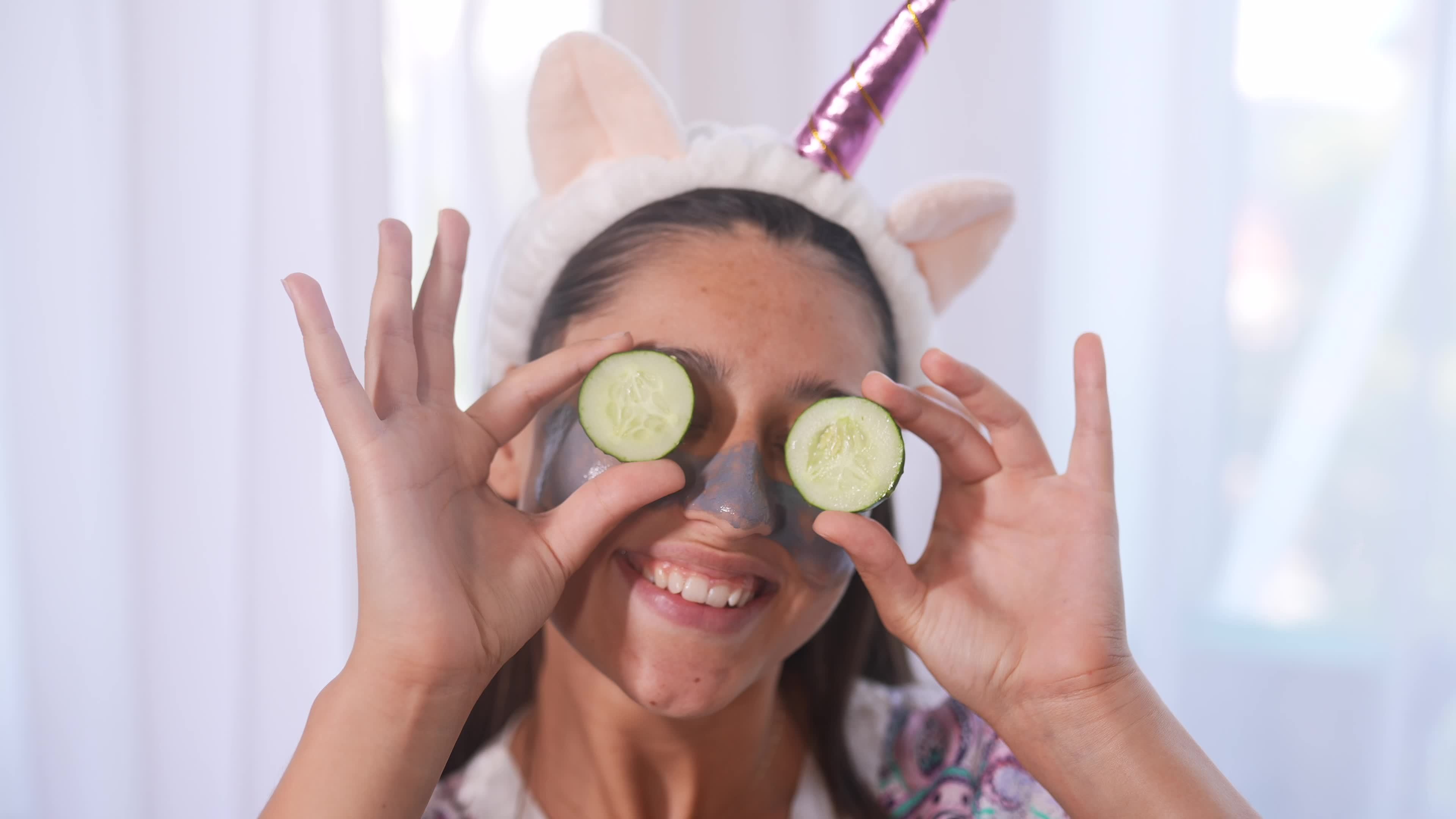 Young beautiful woman uses cucumber slices on eyes during skin care